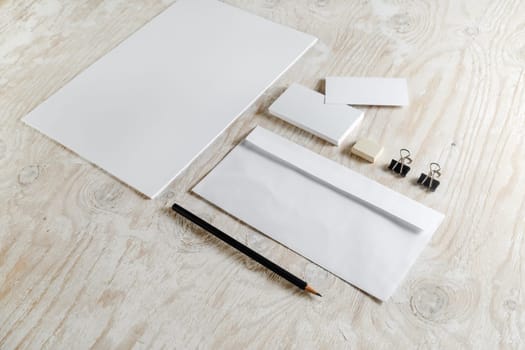 Stationery set on light wooden background. Blank template for design presentations and portfolios.