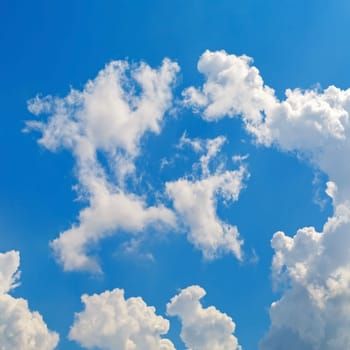 Cumulus clouds against a bright blue sky.