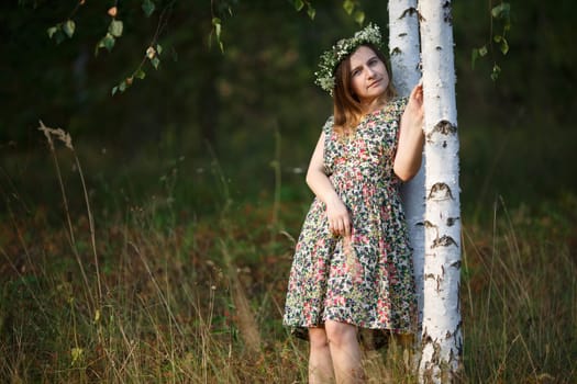Girl with a wreath of wild flowers. Sunset light. Shallow depth of field. Focus on model.