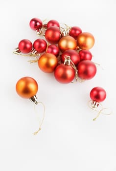 Bright shiny red and orange Christmas balls on a light background. Shallow depth of field. Selective focus. Space for text. Vertical shot.