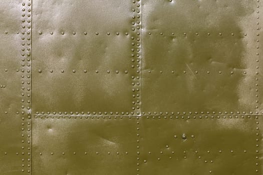 Abstract military green metal plates background texture with seams and rivets.