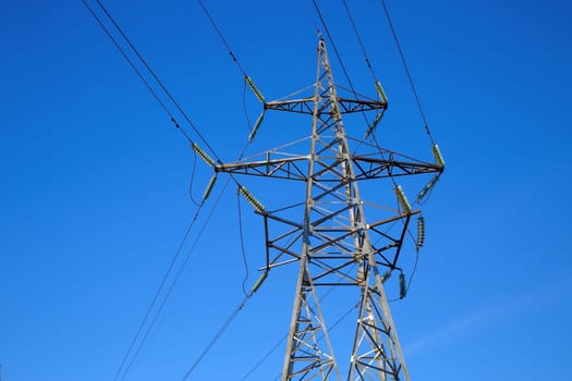Electricity pylon on blue sky background. High voltage tower.
