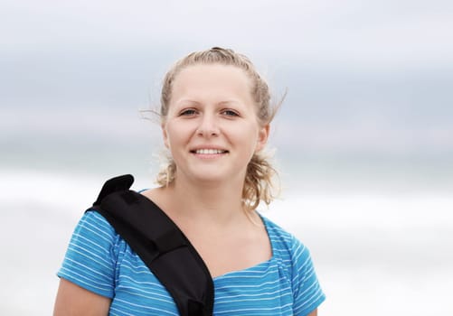 Photo of a smiling young blonde woman outdoor. Close-up of smiling girl. Selective focus on model.