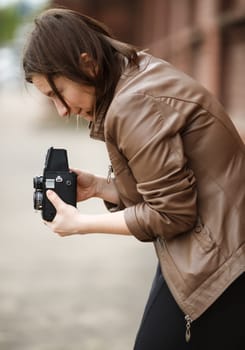 Woman photographer with an old vintage medium format camera. Shallow depth of field. Selective focus on model.