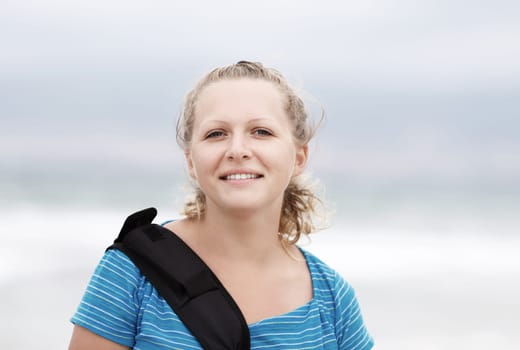 Smiling young blonde woman outdoor. Cheerful young woman. Close-up portrait of a smiling girl. Focus on the model's face.