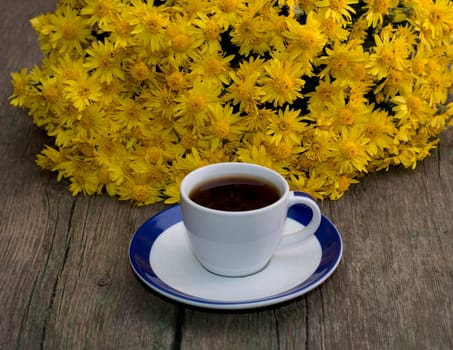 cup of coffee and beautiful bouquet of flowers, on a wooden table, a subject flowers and drinks