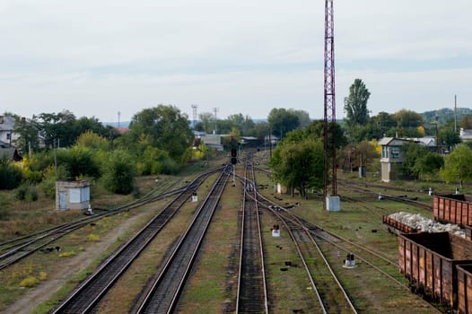 red light signal on a railway fork, railway tracks, a road subject