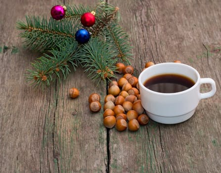 fir-tree branch, hazelnuts and a cup of coffee, a festive card, the subject Christmas and New Year