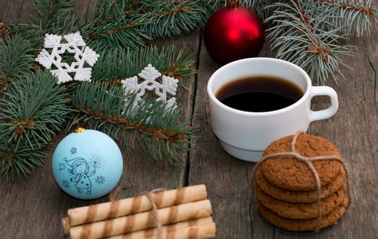 still life a fir-tree branch with jewelry, two linking of cookies and a cup of coffee, a festive card, the subject Christmas and New Year