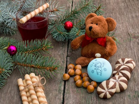 three fir-tree branches, cup of tea, sweets and toy bear, still life, subject Christmas and New Year