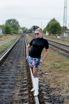 the sexy woman in white boots and sunglasses on rails, railway tracks, a subject beautiful women