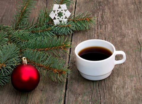 still life a fir-tree branch with brightly red ornament and a cup of coffee, a festive card, the subject Christmas and New Year