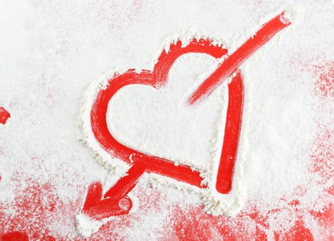 Heart with arrow drawn in the white flour.