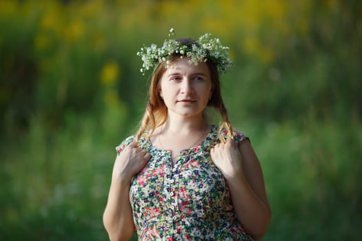 Woman with a wreath on his head holding his hair. Sunset light. Shallow depth of field. Focus on eyes.
