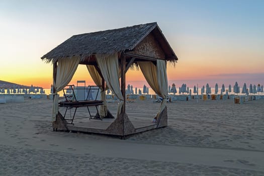Massage canopy on a sandy beach in the early morning. Shallow depth of field. Focus on foreground.