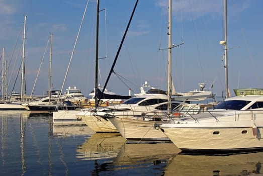 Beautiful white modern luxury yachts at seaport. Sunny summer day.