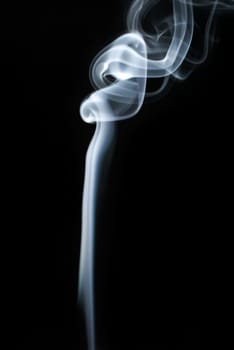 Abstract smoke swirls on black background. Vertical shot.