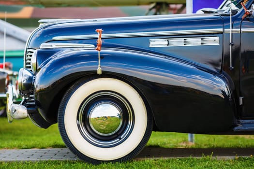 Vintage black car. Old black retro car. Fender and the front wheel of the car. Side view. Selective focus.