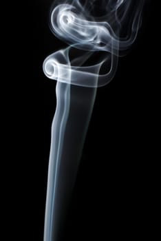 Photo of abstract light smoke swirls on black background. Vertical shot.