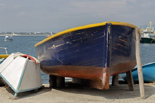 Two old abandoned weathered rowing boats lying on the sand on the beach