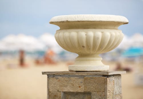 Gypsum vase in the old antique style on the street in bright sunny day. Shallow depth of field.