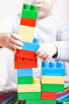 Playing little boy with colored cubes