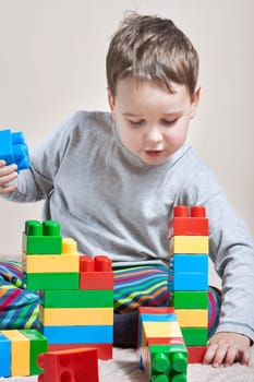 Playing little boy with colored cubes