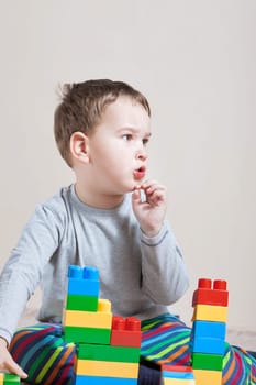 Playing little boy with colored cubes