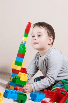 Playing little boy with colored cubes