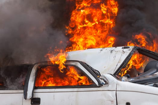 burning and then extinguish an old white car - Exercise firefighters