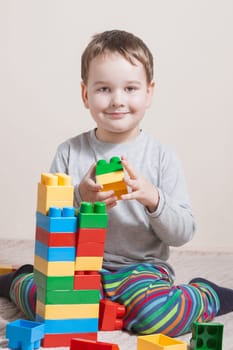 Playing little boy with colored cubes
