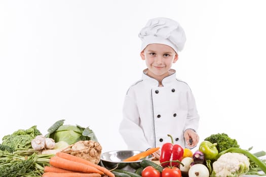 One little boy as chef cook making salad, cooking with vegetables. Isolated on white.