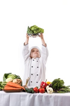 One little boy as chef cook making salad, cooking with vegetables. Isolated on white.
