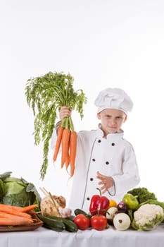 One little boy as chef cook making salad, cooking with vegetables. Isolated on white.
