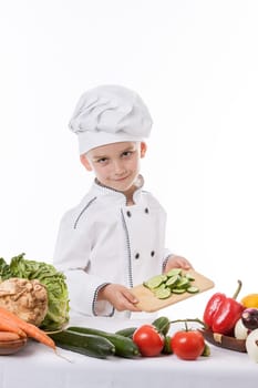 One little boy as chef cook making salad, cooking with vegetables. Isolated on white.