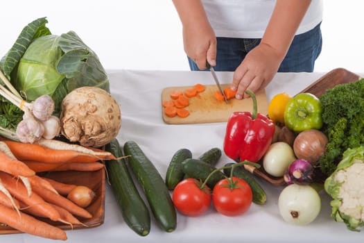 One little boy as chef cook making salad, cooking with vegetables. Isolated on white.