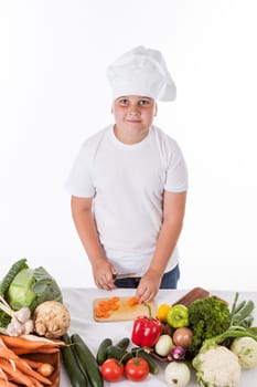 One little boy as chef cook making salad, cooking with vegetables. Isolated on white.