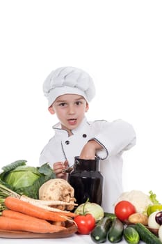 One little boy as chef cook making salad, cooking with vegetables. Isolated on white.