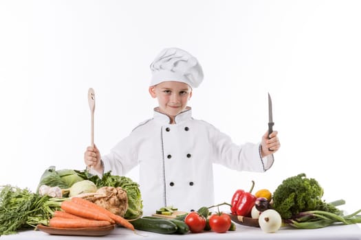 One little boy as chef cook making salad, cooking with vegetables. Isolated on white.