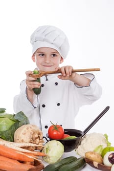 One little boy as chef cook making salad, cooking with vegetables. Isolated on white.