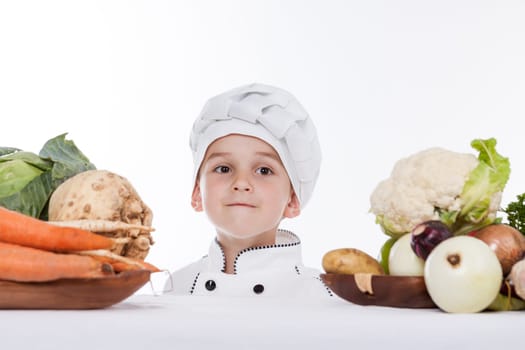 One little boy as chef cook making salad, cooking with vegetables. Isolated on white.