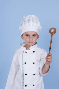 One little boy as chef cook making salad, cooking with vegetables. Isolated on white.