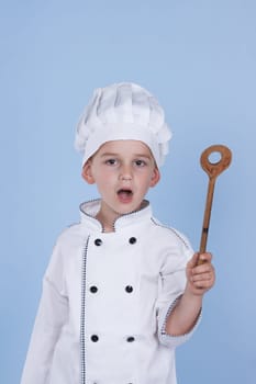 One little boy as chef cook making salad, cooking with vegetables. Isolated on white.