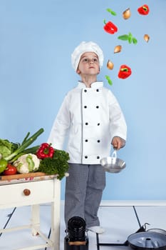 Young chef and his juggling with vegetables in a pan