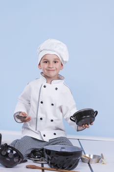 One little boy as chef cook making salad, cooking with vegetables. Isolated on white.