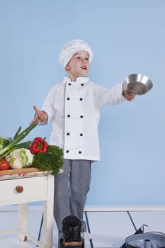 One little boy as chef cook making salad, cooking with vegetables. Isolated on white.