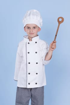 One little boy as chef cook making salad, cooking with vegetables. Isolated on white.