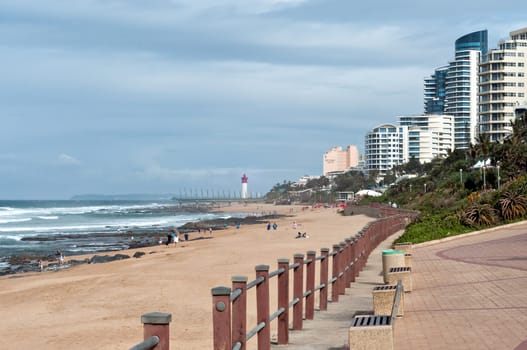 DURBAN, SOUTH AFRICA - JULY 09, 2016: Locals and tourists on the beach near the Millennium Pier and lighthouse in Umhlanga Rocks