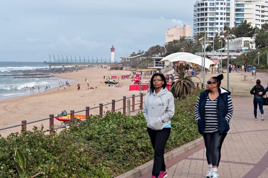DURBAN, SOUTH AFRICA - JULY 09, 2016: Locals and tourists on the beach near the Millennium Pier and lighthouse in Umhlanga Rocks