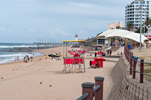 DURBAN, SOUTH AFRICA - JULY 09, 2016: Locals and tourists on the beach near the Millennium Pier and lighthouse in Umhlanga Rocks